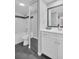 Updated bathroom features gray tile flooring and white vanity with framed mirror at 714 1St Ct, Palm Harbor, FL 34684