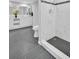 Renovated bathroom features marble tile shower, modern vanity, and black honeycomb shower floor at 714 1St Ct, Palm Harbor, FL 34684