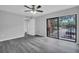 A bright bedroom features wood-look flooring, a ceiling fan, and a balcony at 714 1St Ct, Palm Harbor, FL 34684