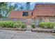 Charming townhome with a unique red tile roof, fenced patio, and landscaped front yard at 714 1St Ct, Palm Harbor, FL 34684