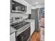 Contemporary kitchen with stainless steel appliances, granite countertops, and tile flooring throughout at 714 1St Ct, Palm Harbor, FL 34684