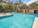 Community pool with clean, clear water, surrounding lounge chairs, and a nearby pool house at 714 1St Ct, Palm Harbor, FL 34684