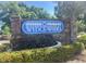 Community sign for Wedgewood with lush landscaping around a brick structure at 714 1St Ct, Palm Harbor, FL 34684