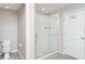 Bathroom with a glass-enclosed shower, white tile and a tile floor and a nearby toilet and door at 7305 Tiger Trail Ct, Sun City Center, FL 33573