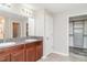 Bathroom featuring a granite double sink vanity and an open door to a walk-in closet at 7305 Tiger Trail Ct, Sun City Center, FL 33573