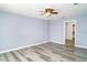 A bright, airy bedroom featuring gray vinyl flooring, ceiling fan and an open door to the walk-in closet at 7305 Tiger Trail Ct, Sun City Center, FL 33573