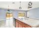 Well-lit kitchen featuring stainless steel appliances, a granite countertop island and sliding door access to the backyard at 7305 Tiger Trail Ct, Sun City Center, FL 33573