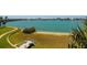 A picturesque backyard featuring manicured lawn, sandy beach, and serene waterfront views at 7872 Sailboat Key S Blvd # 301, South Pasadena, FL 33707