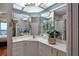 Bright bathroom with a unique ceiling design, white cabinets, marble countertop and framed mirrors at 7872 Sailboat Key S Blvd # 301, South Pasadena, FL 33707