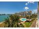 Exterior view of waterfront building with community pool, palms, and blue sky at 7872 Sailboat Key S Blvd # 301, South Pasadena, FL 33707