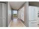 Hallway with view to outdoor patio, art, tile flooring, and white appliances at 7872 Sailboat Key S Blvd # 301, South Pasadena, FL 33707