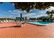 Inviting community pool area with lounge chairs, tables, and a view of nearby buildings and palm trees at 7872 Sailboat Key S Blvd # 301, South Pasadena, FL 33707