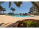 A welcoming pool area with lounge chairs, palm trees, and colorful flowerbeds at 7872 Sailboat Key S Blvd # 301, South Pasadena, FL 33707