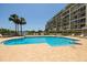 Inviting pool area with clear blue water, tiled deck, and a glimpse of the condo building at 7872 Sailboat Key S Blvd # 301, South Pasadena, FL 33707