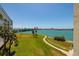 Scenic view from a balcony overlooking lush green space and serene waterfront with a bridge in the distance at 7872 Sailboat Key S Blvd # 301, South Pasadena, FL 33707