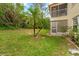View of backyard with lawn, palm trees, and screened in porch on a two-story condo unit at 7910 Hardwick Dr # 717, New Port Richey, FL 34653