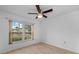 Bright bedroom with wood floors, ceiling fan, and natural light from the window at 7910 Hardwick Dr # 717, New Port Richey, FL 34653