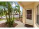 Exterior view of the property entrance, showcasing tropical landscaping, concrete pathway, and entrance door at 7910 Hardwick Dr # 717, New Port Richey, FL 34653