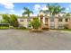 Two story condominium building with tropical landscaping, reserved parking, and exterior stairs at 7910 Hardwick Dr # 717, New Port Richey, FL 34653