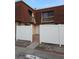 Townhouse with a white fence, red brick walk way and dark windows at 8114 Oak Trace Way # D, Tampa, FL 33634