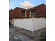 Townhouse with a white fence, red brick walk way and dark windows at 8114 Oak Trace Way # D, Tampa, FL 33634