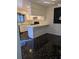 Traditional kitchen featuring white cabinetry, black tile floors, and a peninsula counter at 8114 Oak Trace Way # D, Tampa, FL 33634