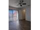 Bright living room with dark wood floors, ceiling fan, and sliding door access to balcony at 8114 Oak Trace Way # D, Tampa, FL 33634