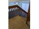 Carpeted staircase with wood railings leads to the upper level of this home at 8114 Oak Trace Way # D, Tampa, FL 33634