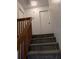 Carpeted staircase with wood railings leads to the upper level of this home at 8114 Oak Trace Way # D, Tampa, FL 33634