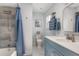 Bathroom featuring blue vanity, framed mirror, and shower with blue curtain, creating a fresh ambiance at 854 77Th N Ave, St Petersburg, FL 33702