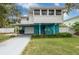 Two-story home with a carport, blue accent paint, and well-manicured lawn at 854 77Th N Ave, St Petersburg, FL 33702