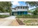 Charming two-story home with a blue foundation, carport, manicured front lawn and privacy fence at 854 77Th N Ave, St Petersburg, FL 33702