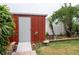 Well-maintained backyard shed surrounded by lush greenery, with a charming bird bath and tidy landscaping at 854 77Th N Ave, St Petersburg, FL 33702