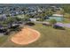 Aerial view of community baseball diamond, tennis courts, and playground at 8736 Huntfield St, Tampa, FL 33635