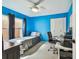 A bedroom shows a blue wall, a single bed, a desk and a closet at 8736 Huntfield St, Tampa, FL 33635
