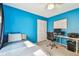 A bedroom shows a blue wall, a single bed, a desk and a closet at 8736 Huntfield St, Tampa, FL 33635