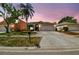 Charming single-Gathering home with a well-maintained lawn and a two-car garage, set against a dusk sky at 8736 Huntfield St, Tampa, FL 33635