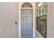 Close-up of a gray front door with sidelight, complementing the stucco exterior, provides an inviting entry at 8736 Huntfield St, Tampa, FL 33635