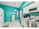 Bright kitchen features white cabinets, tile flooring and turquoise walls at 8736 Huntfield St, Tampa, FL 33635