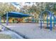 Community playground with slides, swings, picnic tables, and shaded seating at 8736 Huntfield St, Tampa, FL 33635