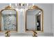 Bathroom featuring double vanity, marble-style walls, and bronze framed mirrors at 8740 15Th N St, St Petersburg, FL 33702