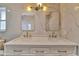 Bathroom featuring marble-style tiling, double vanity and mirrors with bronze hardware at 8740 15Th N St, St Petersburg, FL 33702