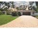 Beautiful home featuring a large brick driveway and well-manicured lawn at 8740 15Th N St, St Petersburg, FL 33702