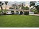Charming home with a manicured lawn, arched windows, and mature palm trees at 8740 15Th N St, St Petersburg, FL 33702