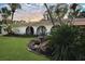 Inviting home with a well-maintained lawn, tropical plants and arched entryway at 8740 15Th N St, St Petersburg, FL 33702
