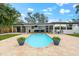 The backyard has a gorgeous in-ground pool and a covered patio with chairs and tables at 8848 Sunlit Cove Ne Dr, St Petersburg, FL 33702