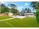 The landscaped backyard features artificial grass, a pool, and a paved patio for outdoor relaxation at 8848 Sunlit Cove Ne Dr, St Petersburg, FL 33702