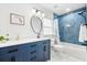 Stylish bathroom with a blue vanity, modern fixtures, and tiled shower at 8848 Sunlit Cove Ne Dr, St Petersburg, FL 33702