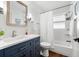 Bathroom featuring a blue vanity, a shower-tub combo, white tile and wood flooring at 8848 Sunlit Cove Ne Dr, St Petersburg, FL 33702