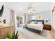 Bright main bedroom features neutral decor, a ceiling fan, sliding glass doors to a patio, and a decorative rug at 8848 Sunlit Cove Ne Dr, St Petersburg, FL 33702